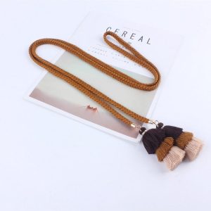 Une élégante ceinture style macramé en coton ornée de pampilles.