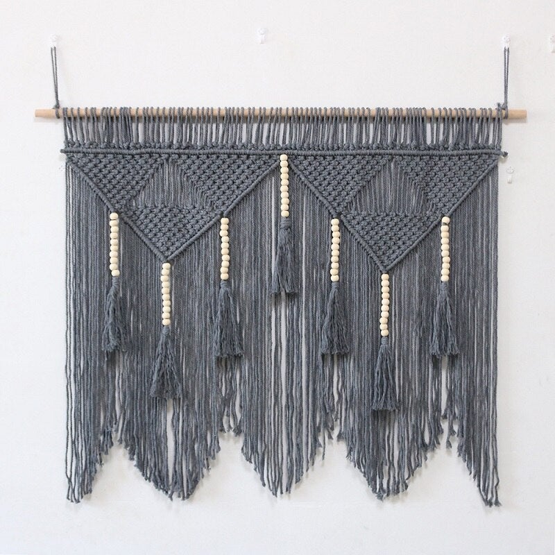Un magnifique macramé mural de couleur grise et de grande taille fait en coton